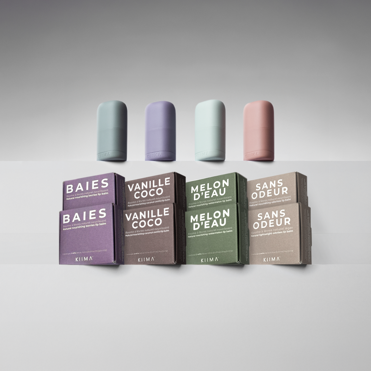 Five cylindrical containers with lids on a gray background, accompanied by boxes labeled with product names.