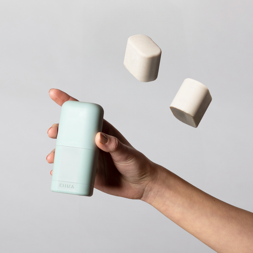 KIIMA refillable applicator in a hand, with 2 natural deodorant refills floating above, eco-friendly packaging