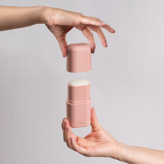 2 handsclosing a KIIMA refillable pink applicator, with a natural deodorant inside, eco-friendly packaging