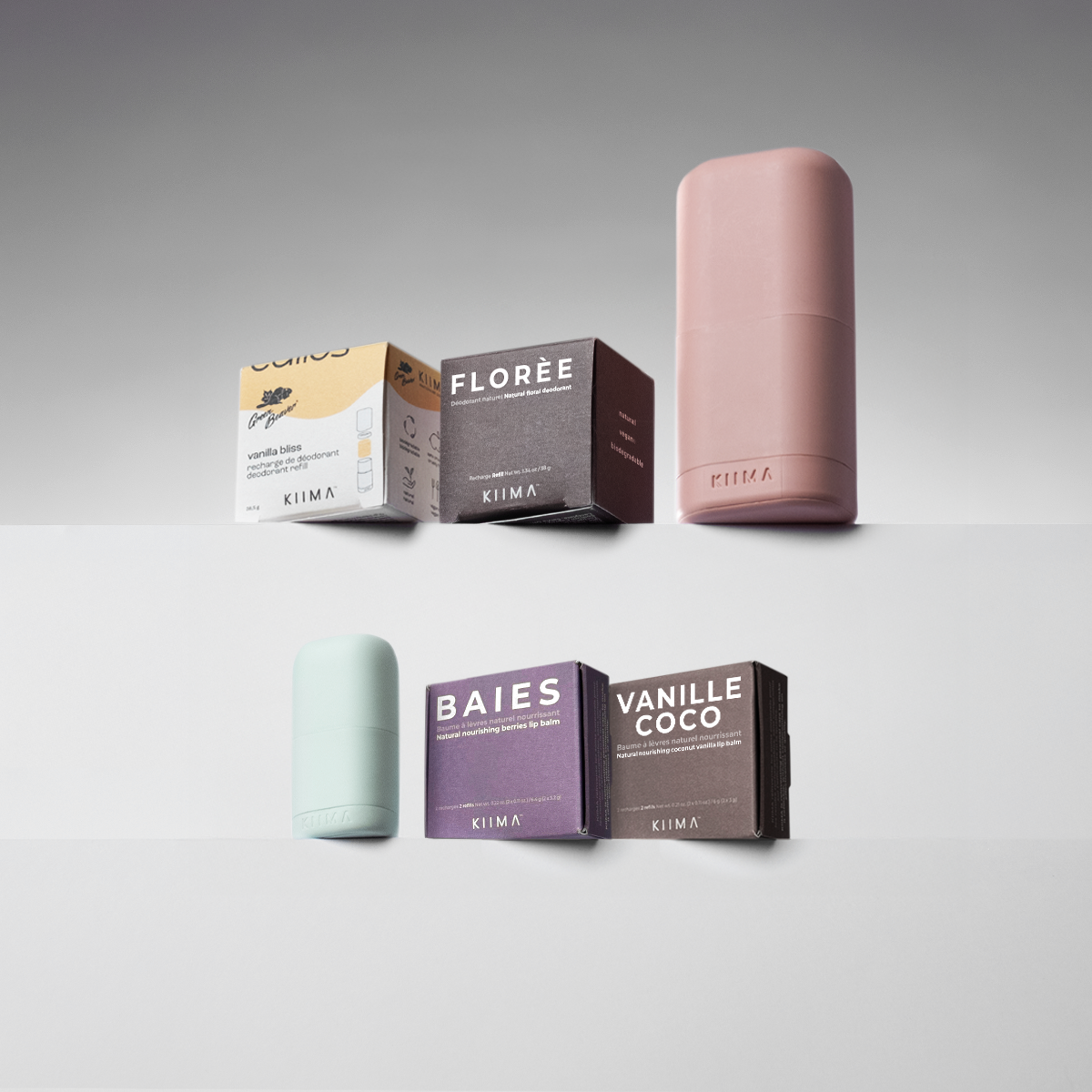 Collection of cosmetic containers and boxes with visible branding on a gray background