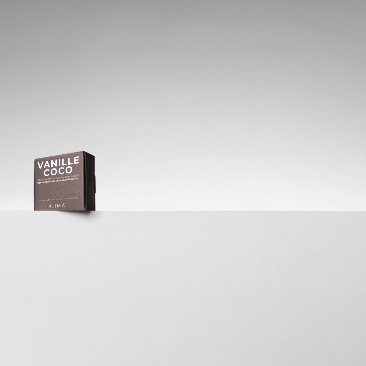 Animated reveal of KIIMA refillable lip balm and assorted cardboard refills like Vanille Coco and Melon d'Eau.