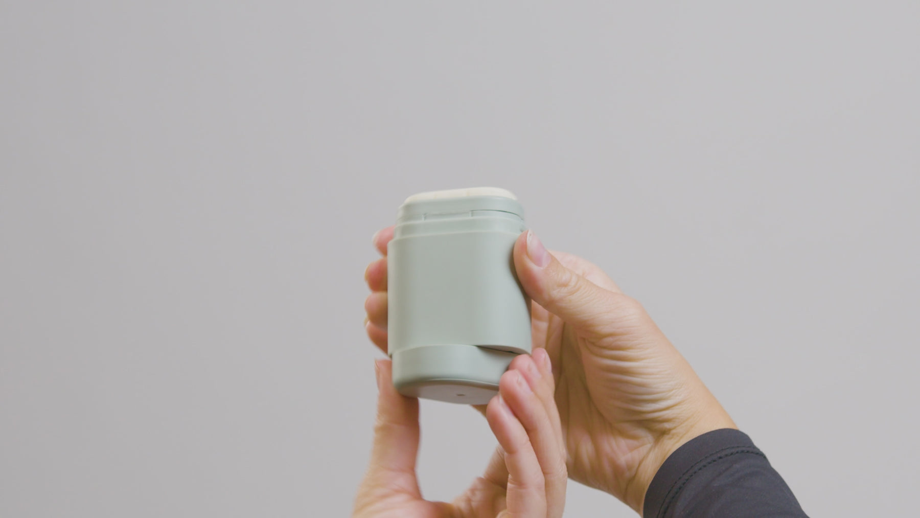 Demonstrating the KIIMA zero-waste process: removing the clip with the remaining deodorant, rotating the base fully, and placing the old remnant on top of a new refill to ensure no product is wasted.