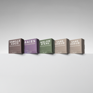 Five lip balm boxes with different scents on a gray background